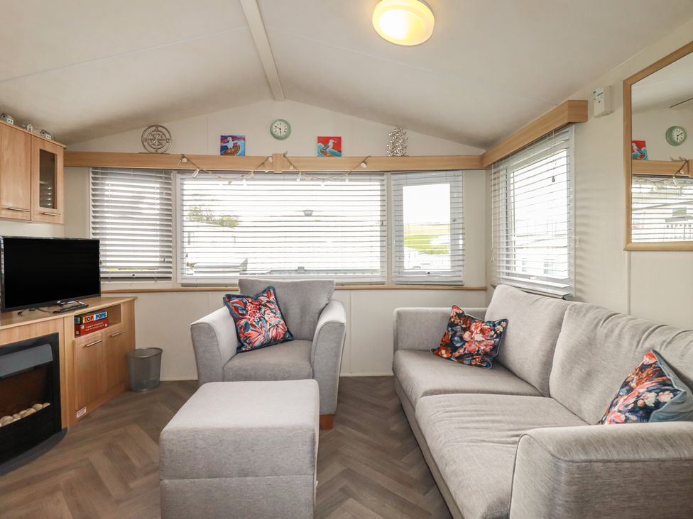 A living room with a sofa and television at Tucked Away in Newquay