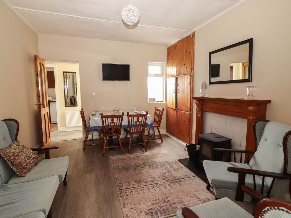 A dining room with a table and chairs at Golf Club View, County Clare