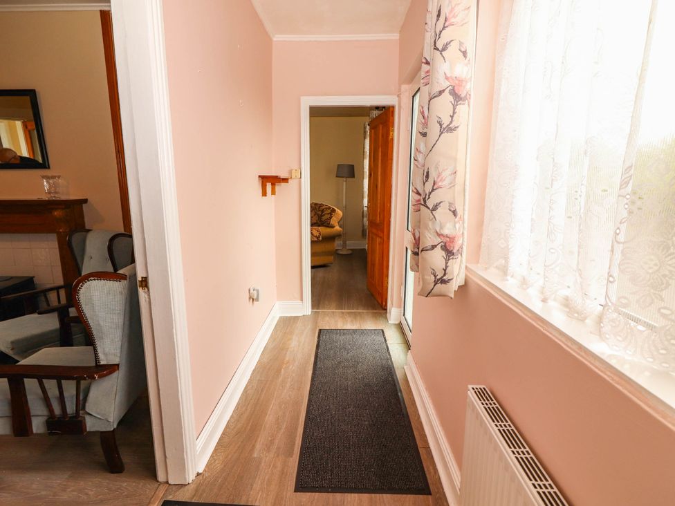 A hallway with a carpet and a lamp at Golf Club View in County Clare