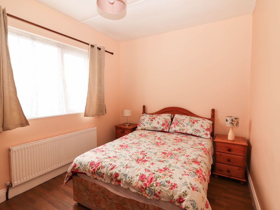 A bedroom with a bed and bedside table at Golf Club View, County Clare