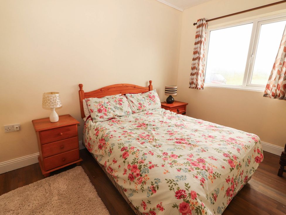 A bedroom with a bed and bedside table at Golf Club View in County Clare