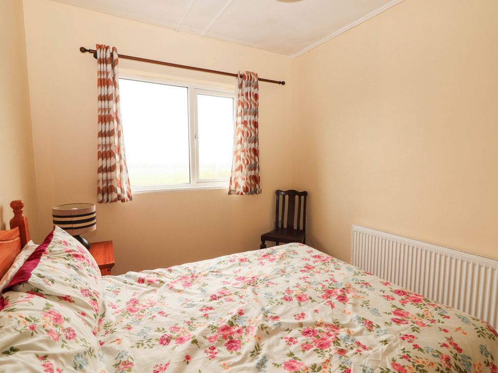 A bedroom with a bed and window at Golf Club View, County Clare