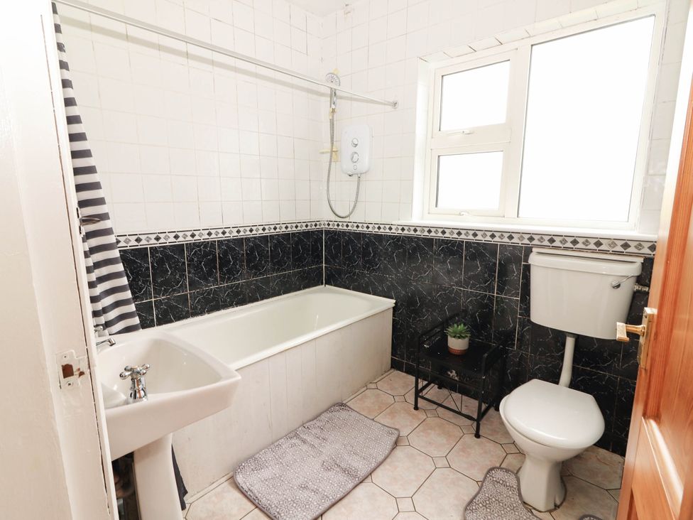 A bathroom with a bathtub and sink at Golf Club View, County Clare