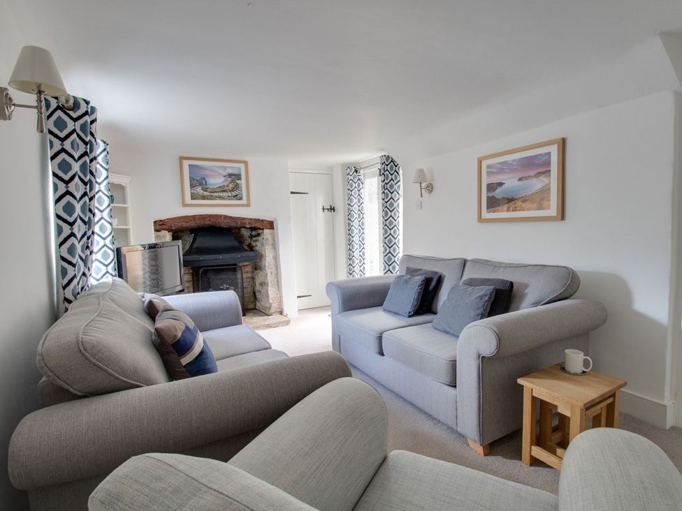 A living room with a sofa and television at Little Wickers in Wareham