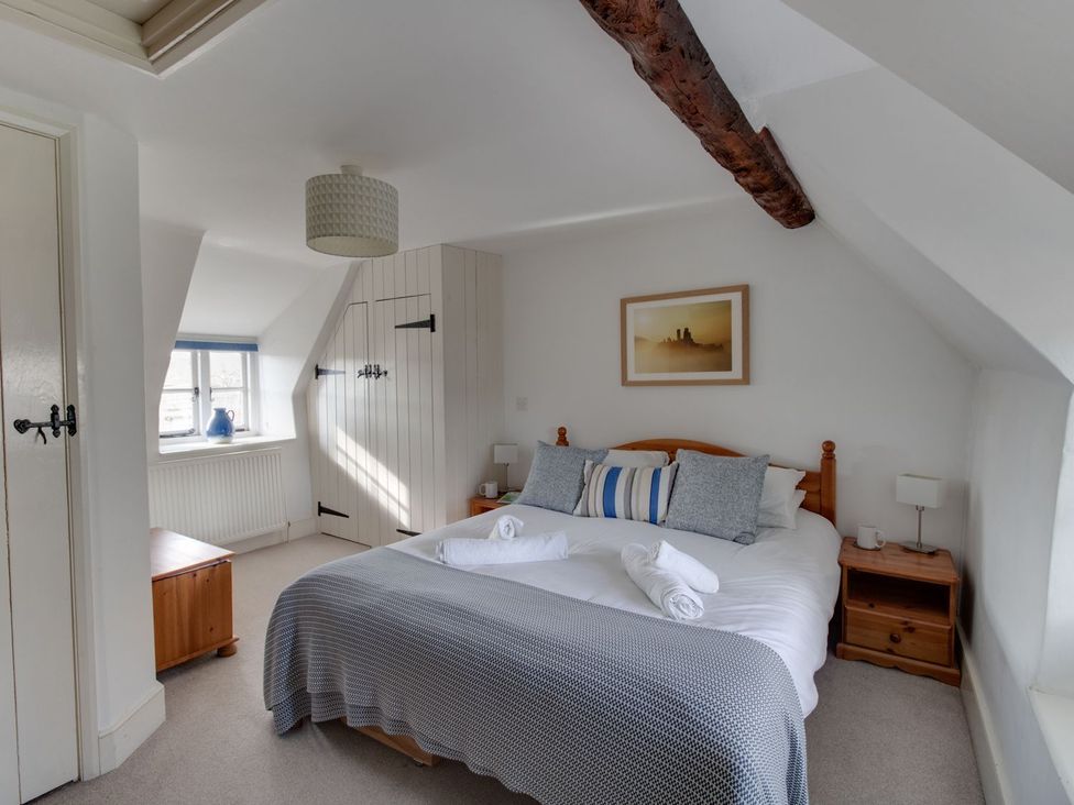 A bedroom with a bed and a window at Little Wickers Wareham