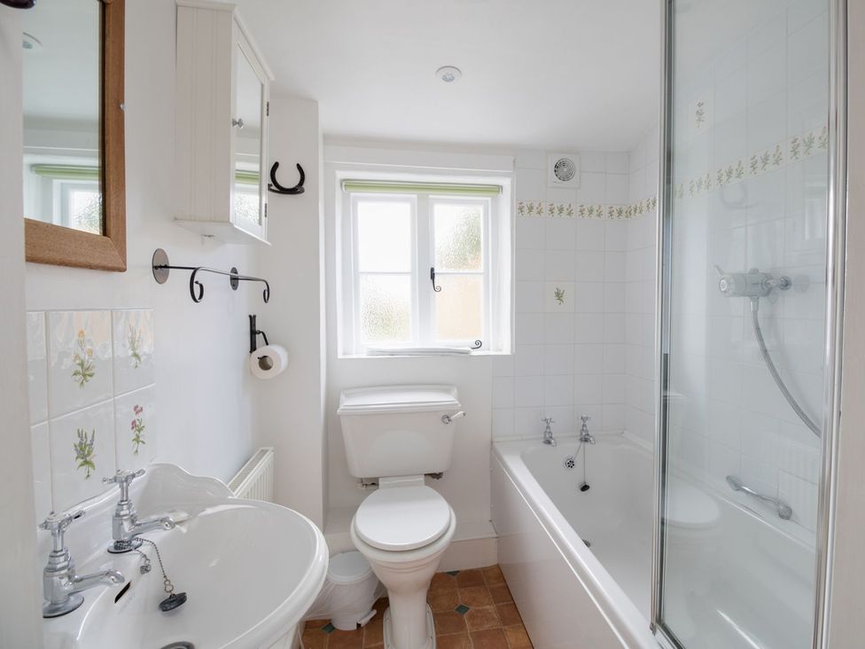 A bathroom with a sink, toilet, bathtub, and shower at Little Wickers in Wareham