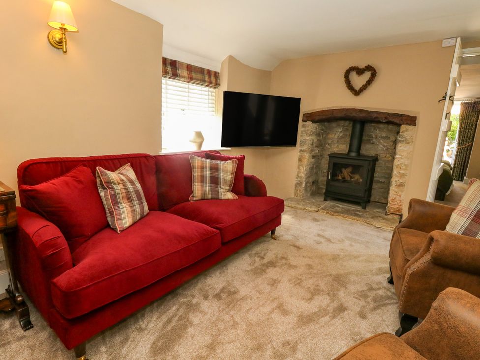 A living room with a sofa and a fireplace at Little Wickers in Corfe Castle