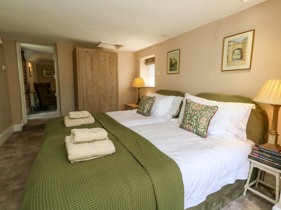 A bedroom with two beds and a wardrobe at Little Wickers in Corfe Castle