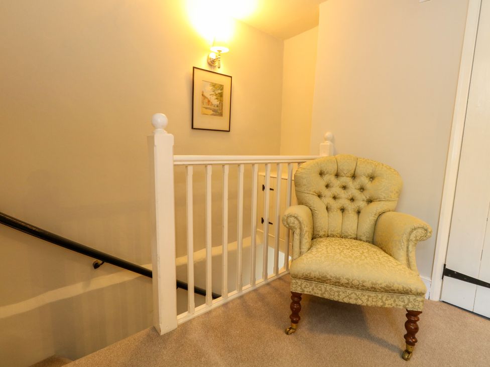 A hallway with a chair near the staircase at Little Wickers in Corfe Castle
