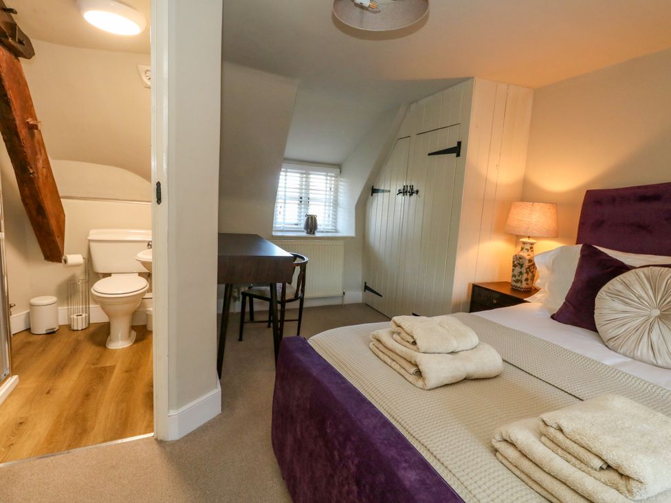 A bedroom with a bed and adjoining bathroom at Little Wickers Corfe Castle