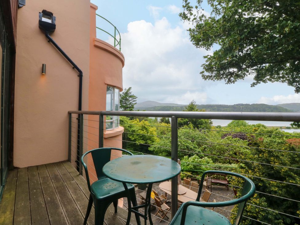 A balcony with a table and chairs overlooking a view at The Treehouse in Colwyn Bay