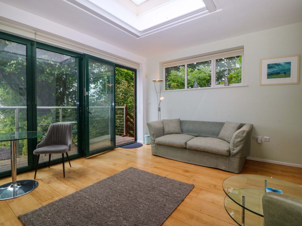 A living room with a sofa and table at The Treehouse in Colwyn Bay