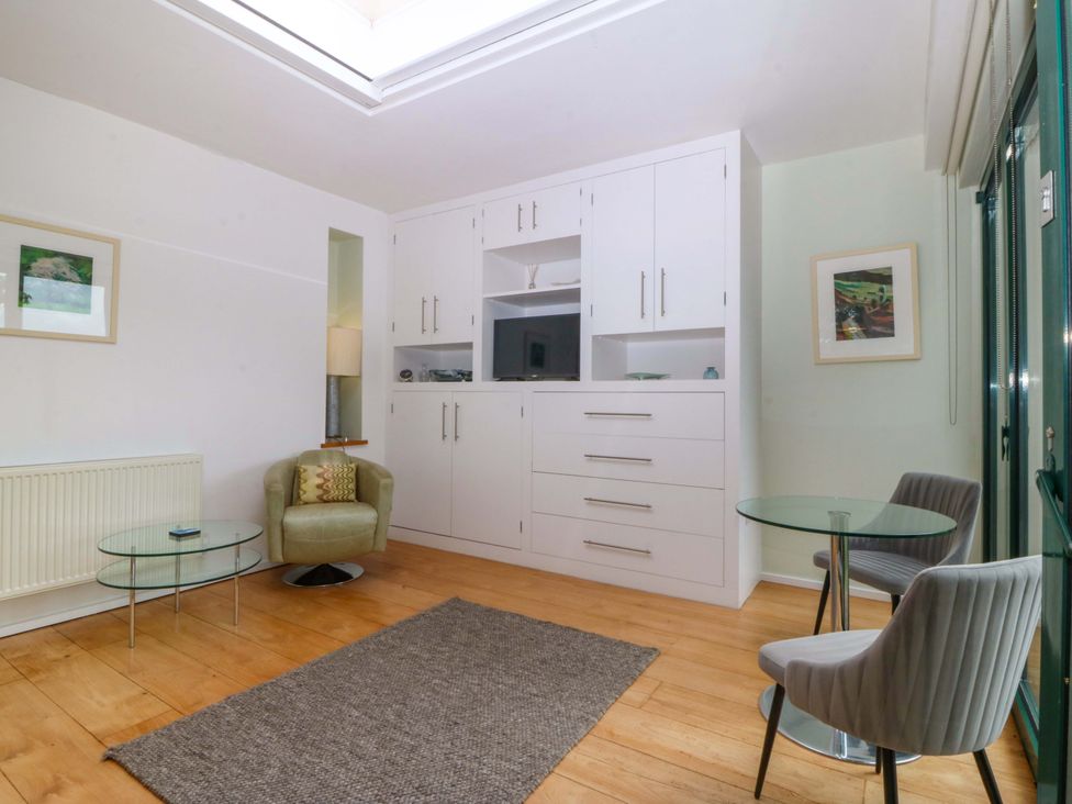 A living room with a sofa and TV unit at The Treehouse in Colwyn Bay