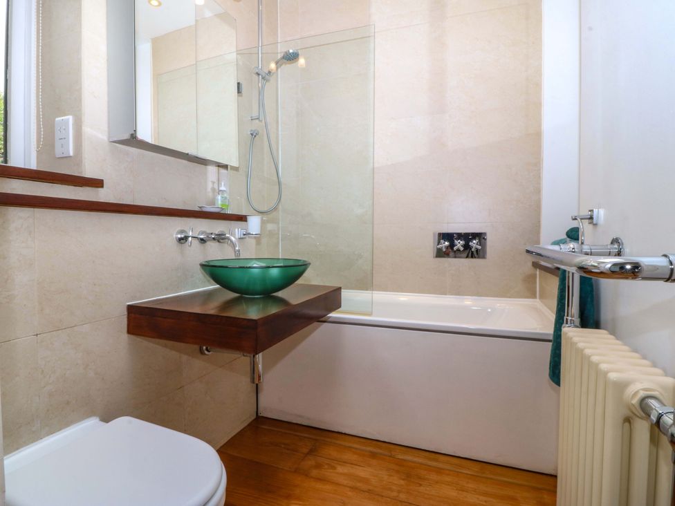 A bathroom with a sink, toilet, and bathtub at The Treehouse in Colwyn Bay