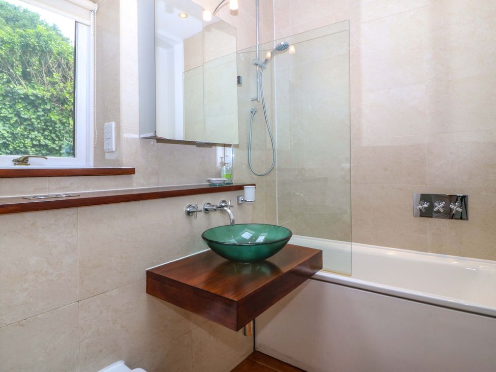 A bathroom with a bathtub and a sink at The Treehouse in Colwyn Bay