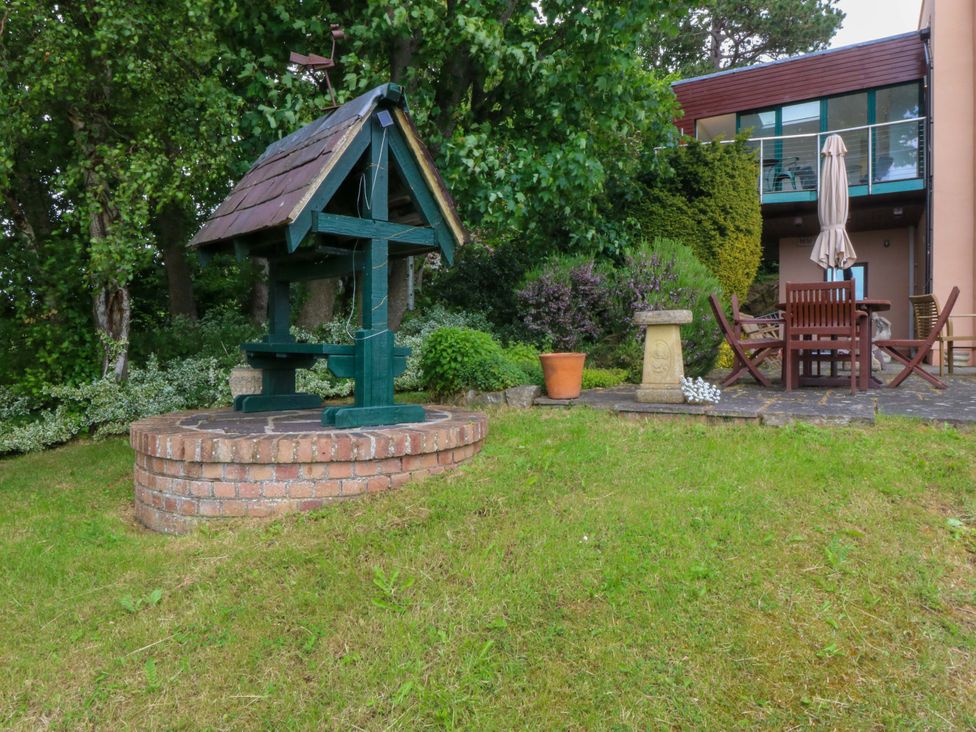 A garden with a well and furniture at The Treehouse in Colwyn Bay