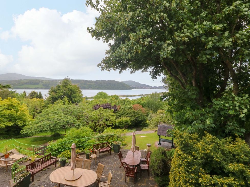 An outdoor area with tables and chairs overlooking a river at The Treehouse in Colwyn Bay