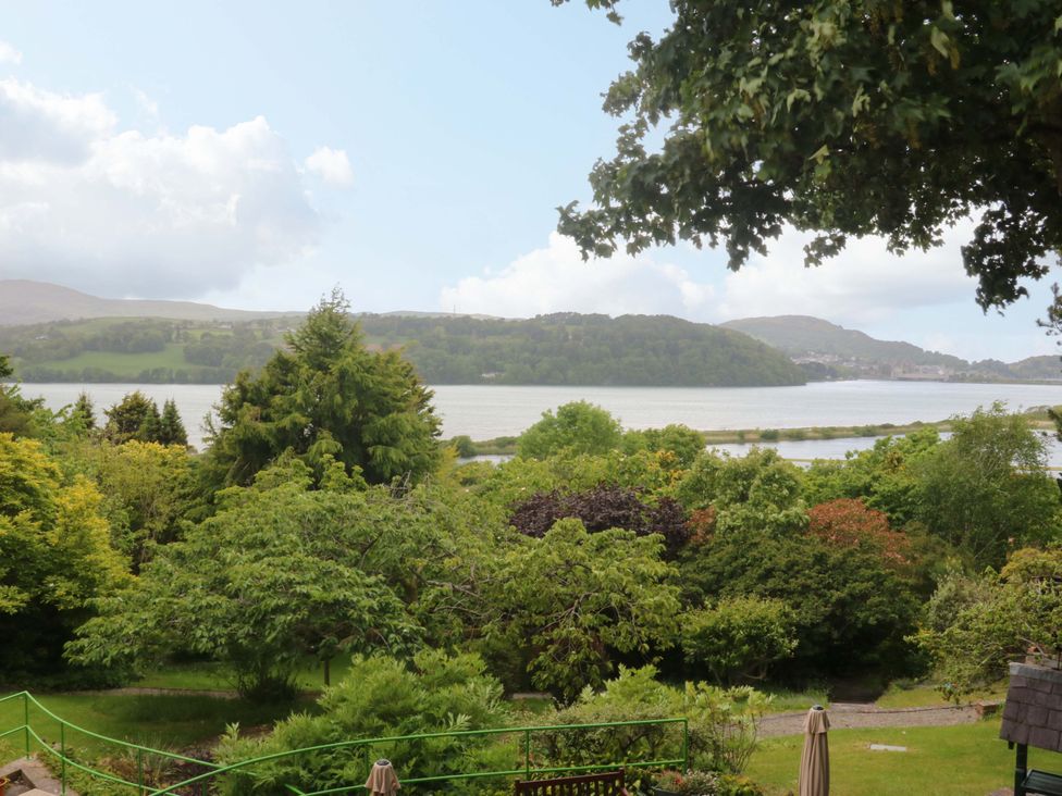 A view of trees and water with hills in the background at The Treehouse in Colwyn Bay
