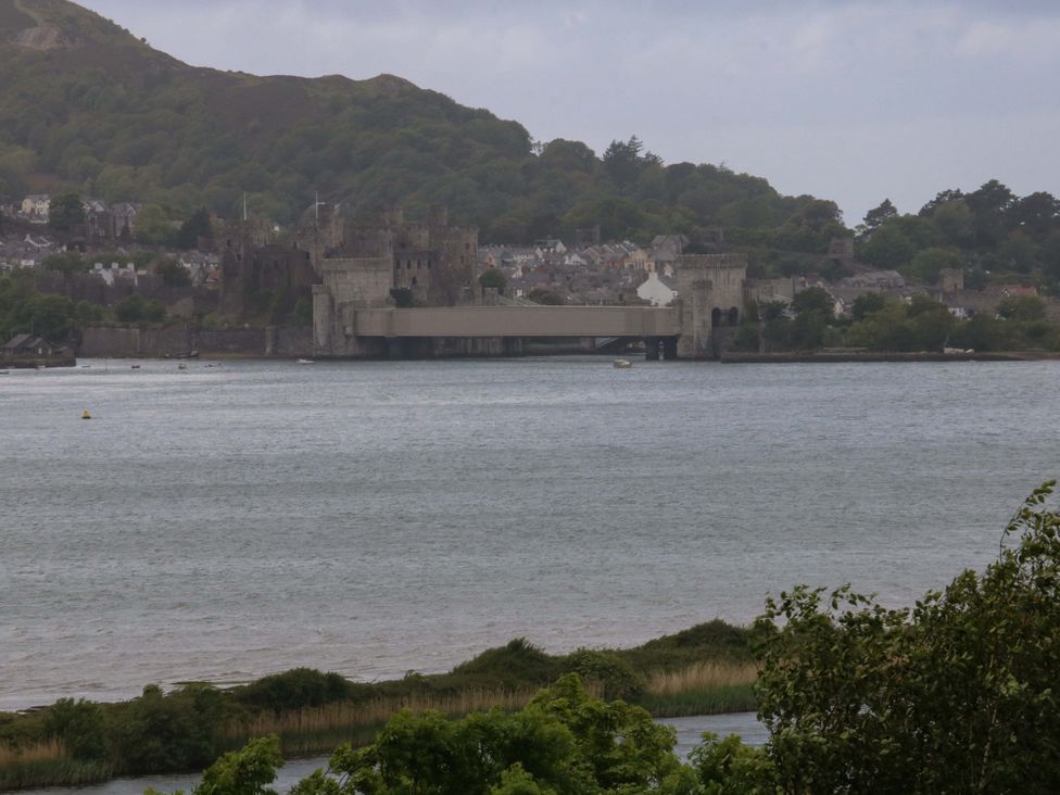 A view of a castle and bridge over a river at The Treehouse in Colwyn Bay