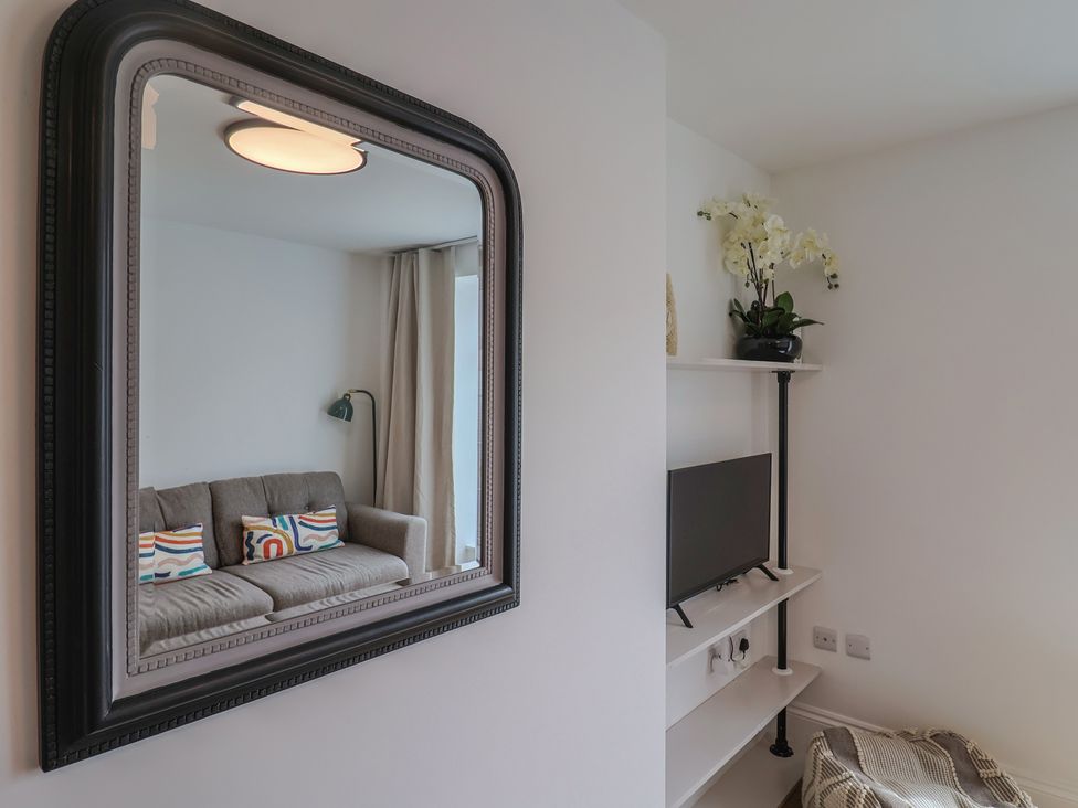 A living room with a sofa and TV at Flat 1 Harley House Sidmouth