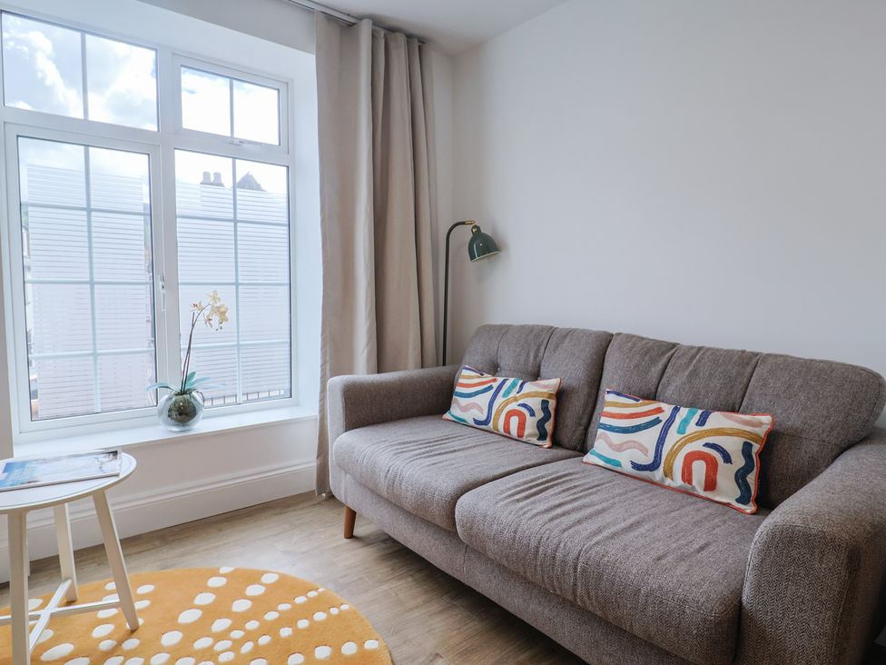 A living room with a sofa and lamp at Flat 1 Harley House in Sidmouth