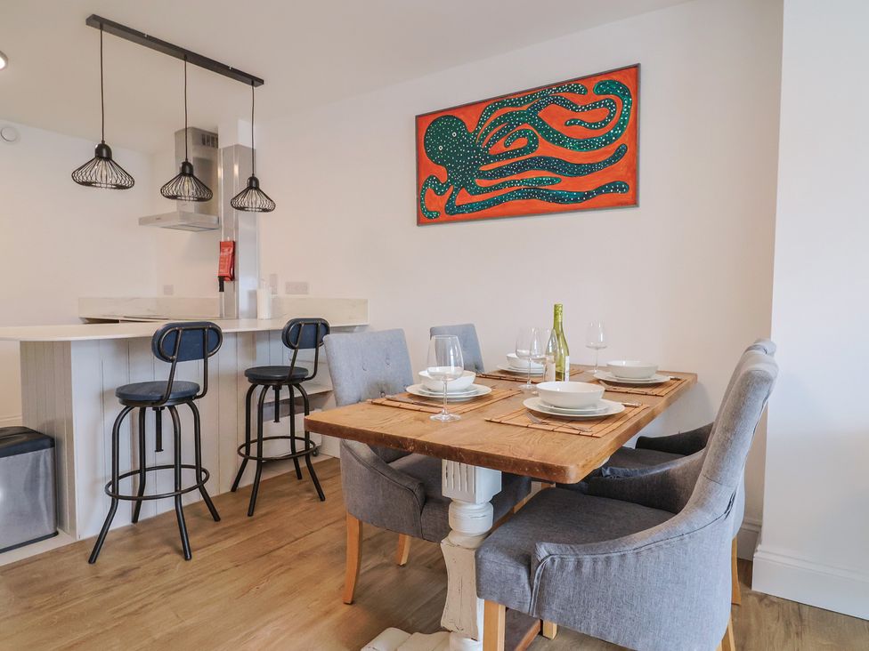 A dining room with a table set for dinner at Flat 1 Harley House in Sidmouth