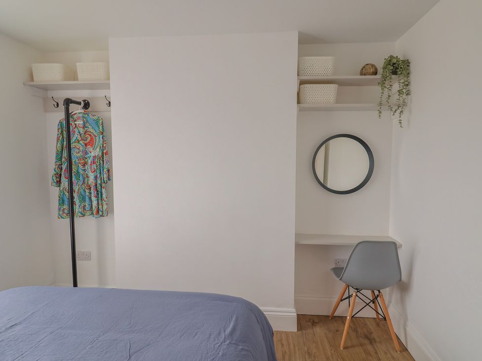 A bedroom with a bed and a desk at Flat 1 Harley House in Sidmouth