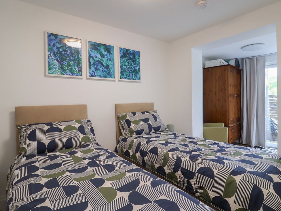 A bedroom with two beds and a wardrobe at Flat 1 Harley House in Sidmouth
