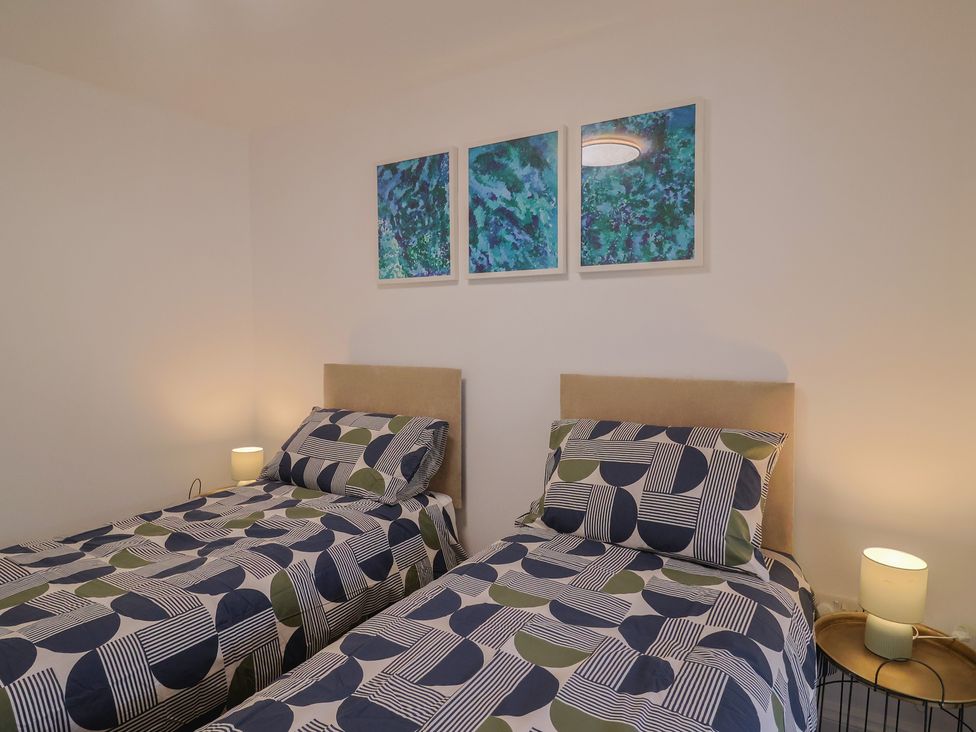 A bedroom with two twin beds and paintings at Flat 1 Harley House Sidmouth