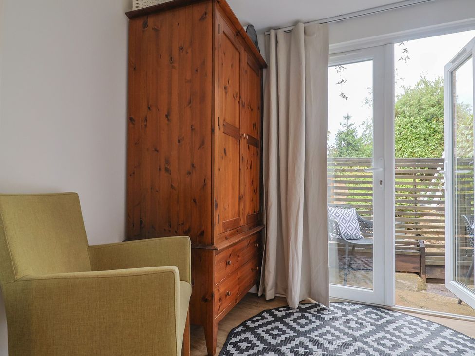 A seating area with an armchair and wardrobe at Flat 1 Harley House, Sidmouth