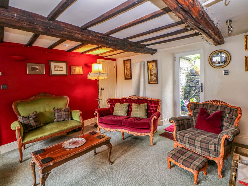 A living room with seating and a view of the garden at Bargate Cottage in Hope Valley