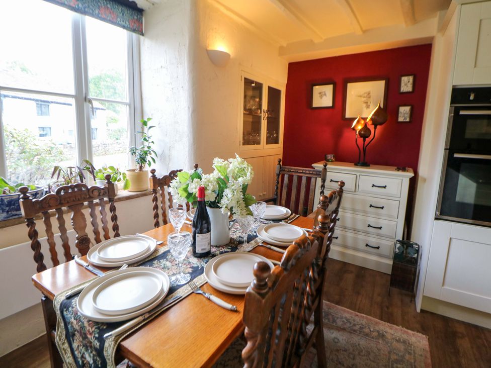 A dining room with a table set for dinner at Bargate Cottage in Hope Valley