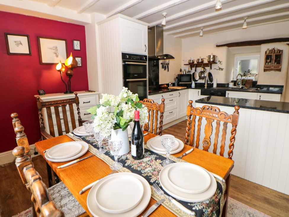 A dining room with a table set for dinner at Bargate Cottage in Hope Valley