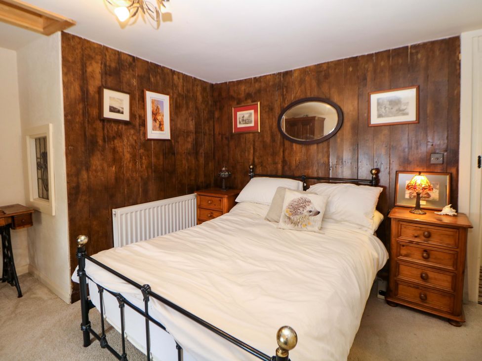 A bedroom with a bed and nightstand at Bargate Cottage in Hope Valley