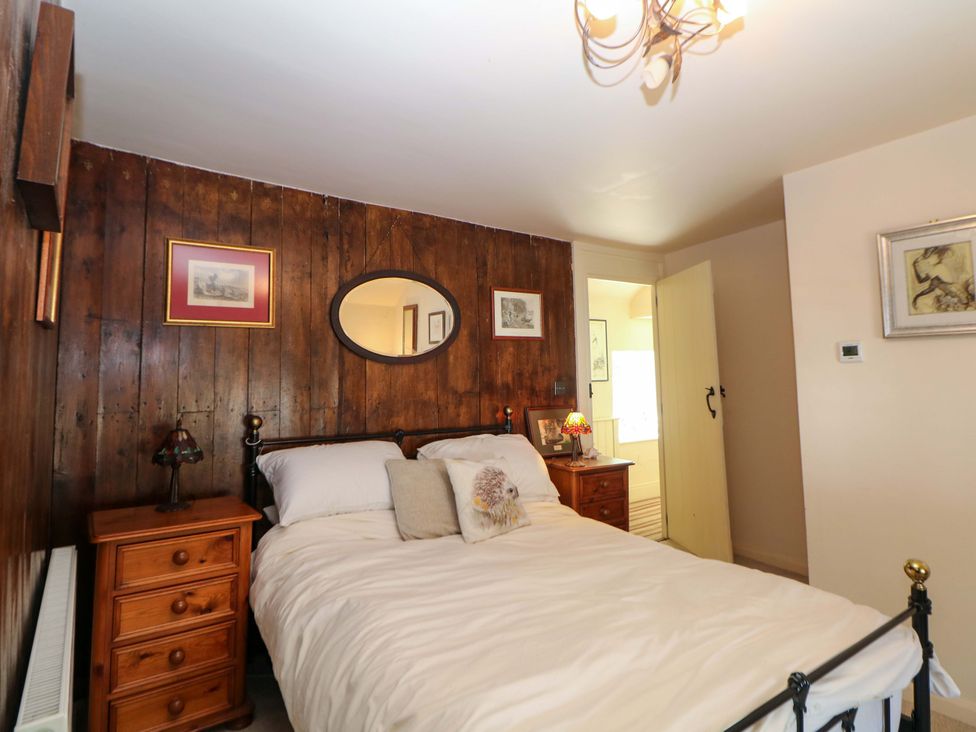 A bedroom with a bed and nightstand at Bargate Cottage in Hope Valley