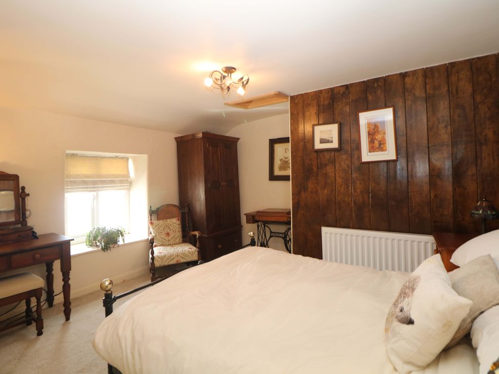 A bedroom with a bed and furniture at Bargate Cottage in Hope Valley