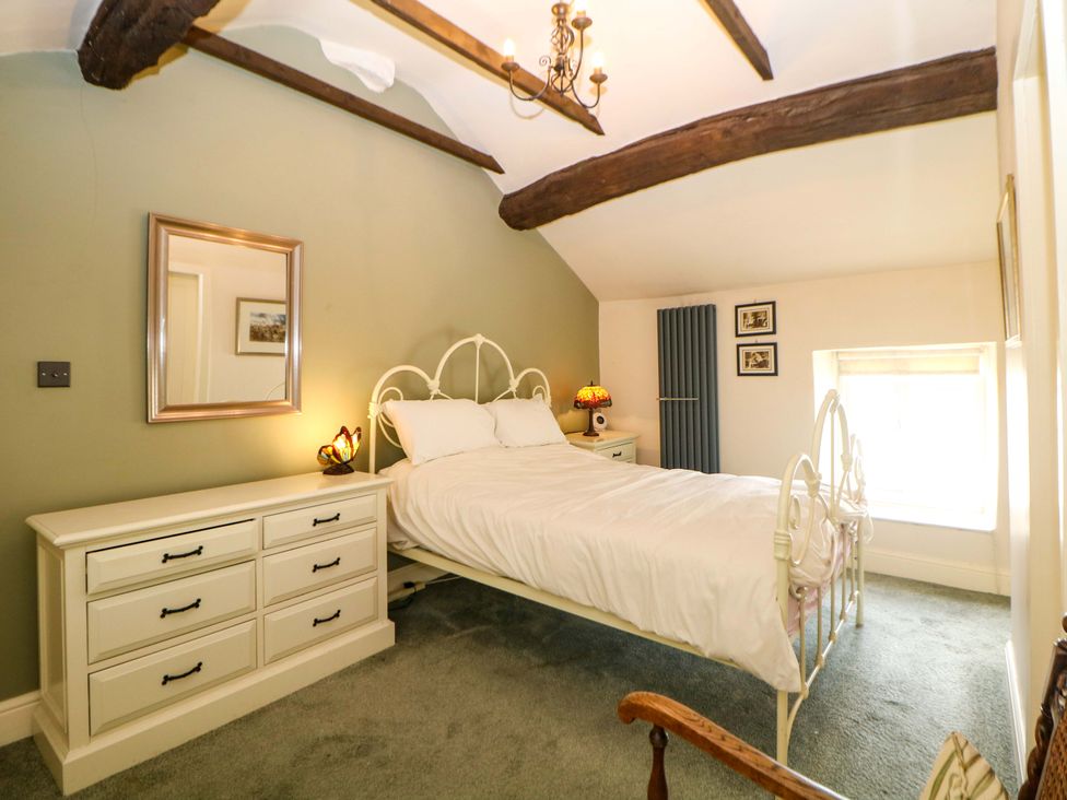 A bedroom with a white bed and chest of drawers at Bargate Cottage in Hope Valley