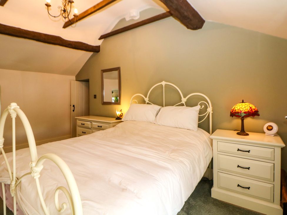 A bedroom with a bed and nightstand at Bargate Cottage in Hope Valley