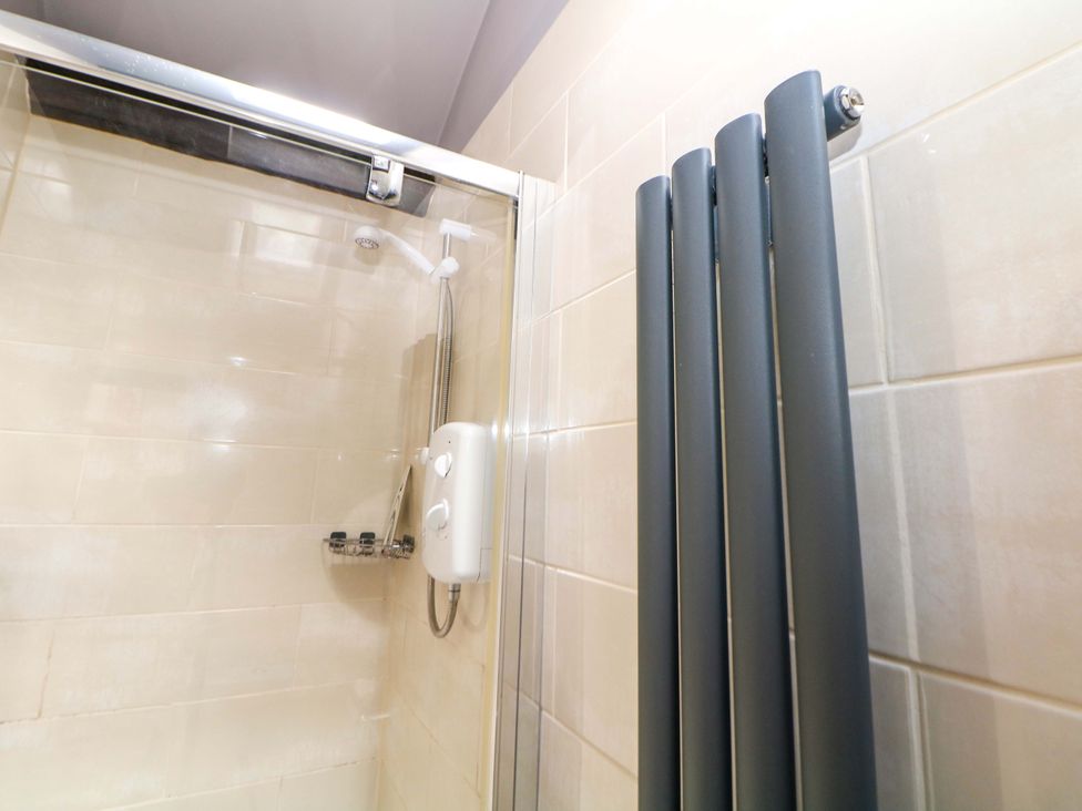 A shower area with showerhead and controls at Bargate Cottage in Hope Valley