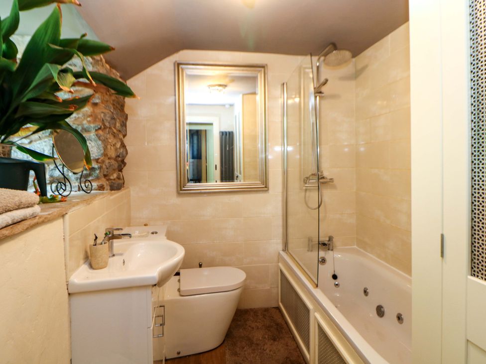 A bathroom with a bathtub, shower, sink and toilet at Bargate Cottage in Hope Valley