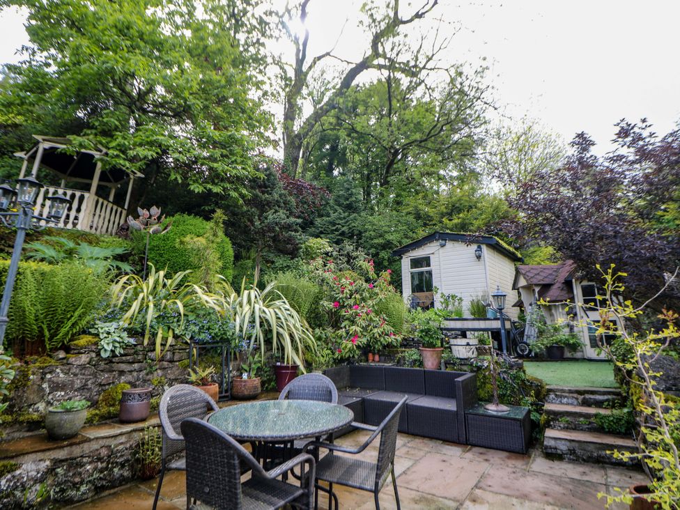 A garden with seating area and shed at Bargate Cottage in Hope Valley