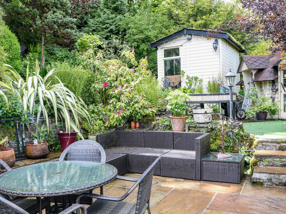 A garden with seating area and shed at Bargate Cottage in Hope Valley
