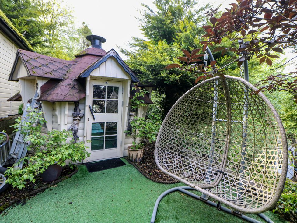 A garden with a shed and a hanging chair at Bargate Cottage in Hope Valley