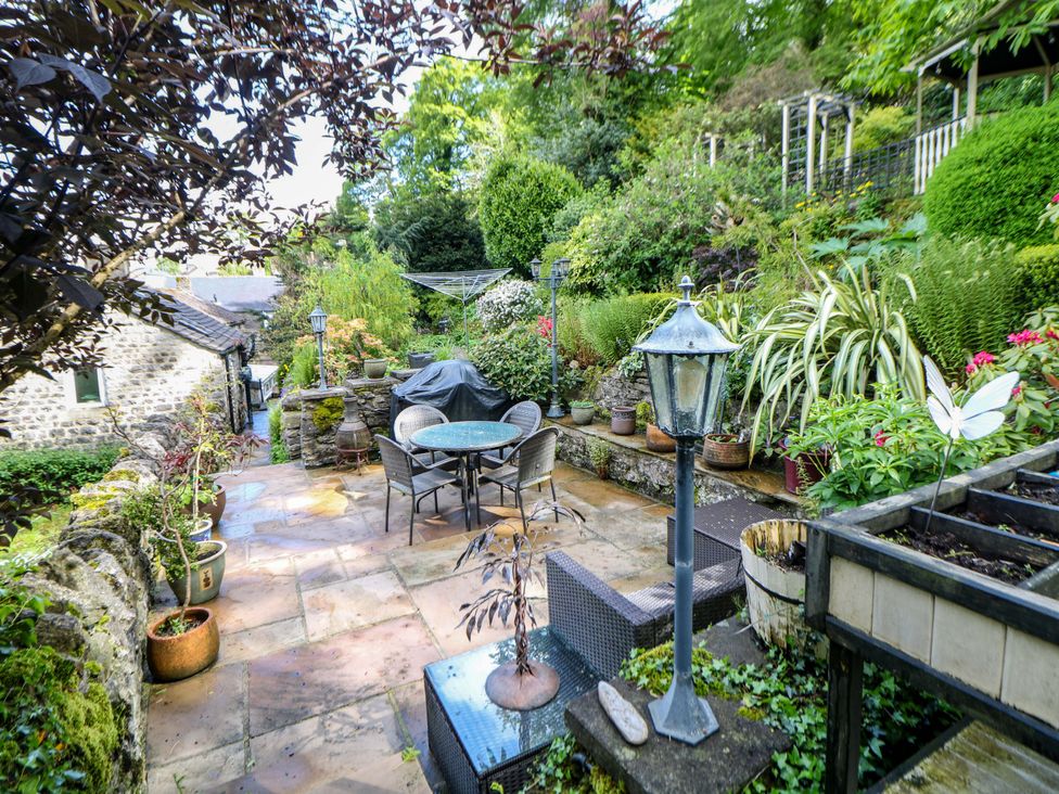 A garden with a table and chairs, and plants at Bargate Cottage, Hope Valley