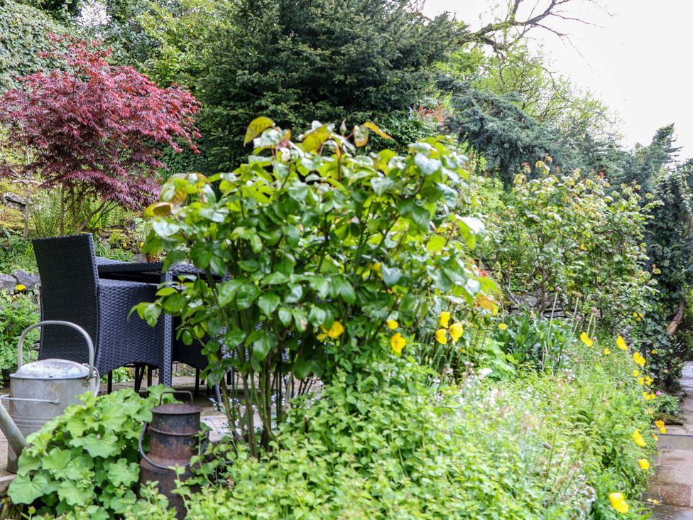 A garden with seating area and various plants at Bargate Cottage in Hope Valley