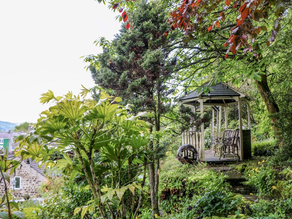 A gazebo with chairs surrounded by plants at Bargate Cottage in Hope Valley