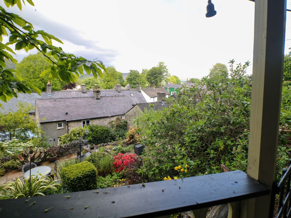 A view of houses and gardens from a balcony at Bargate Cottage in Hope Valley