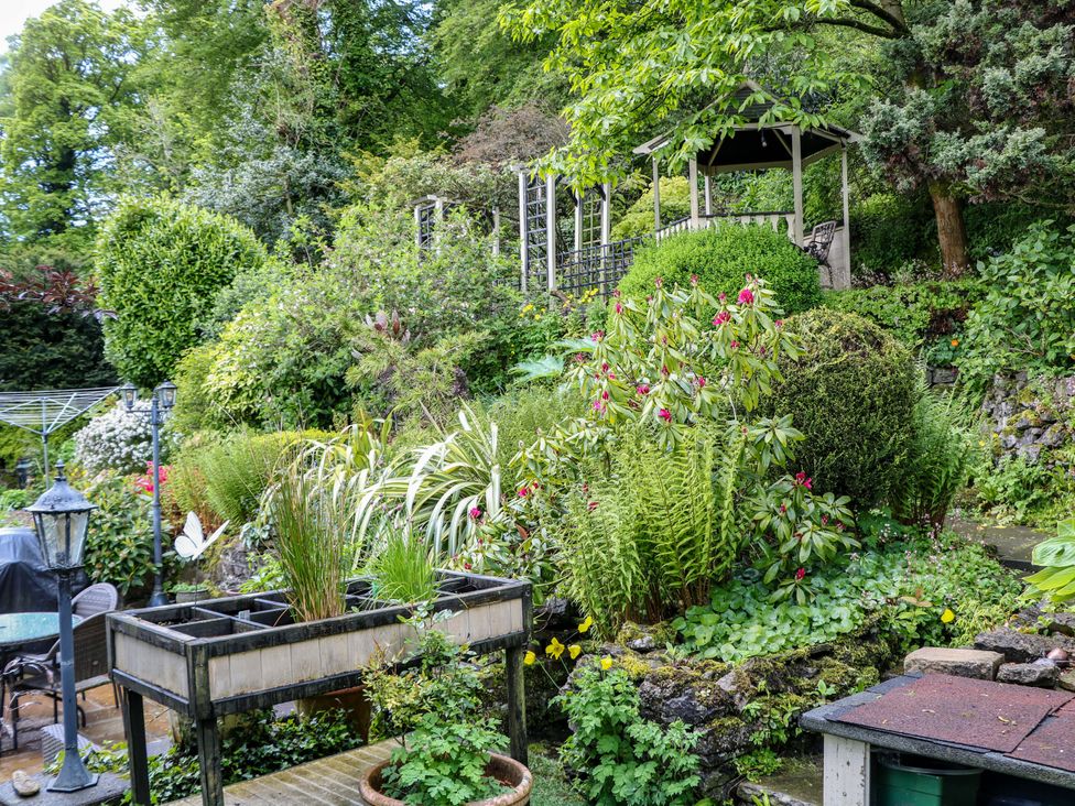 A garden with a gazebo and various plants at Bargate Cottage in Hope Valley