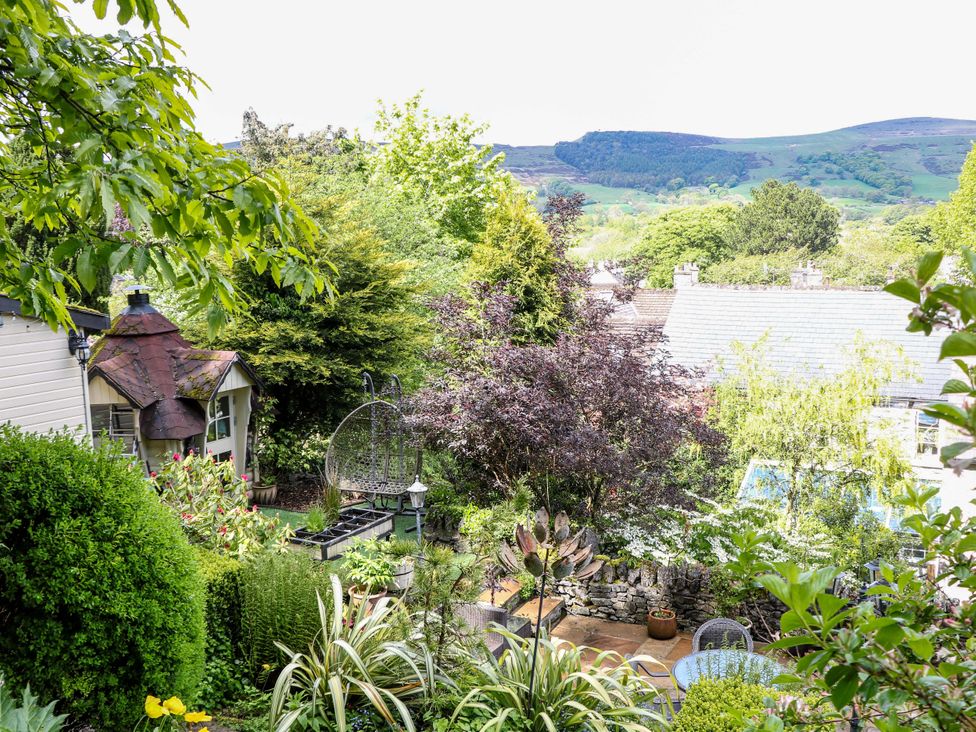 A garden with greenery and furniture at Bargate Cottage Hope Valley