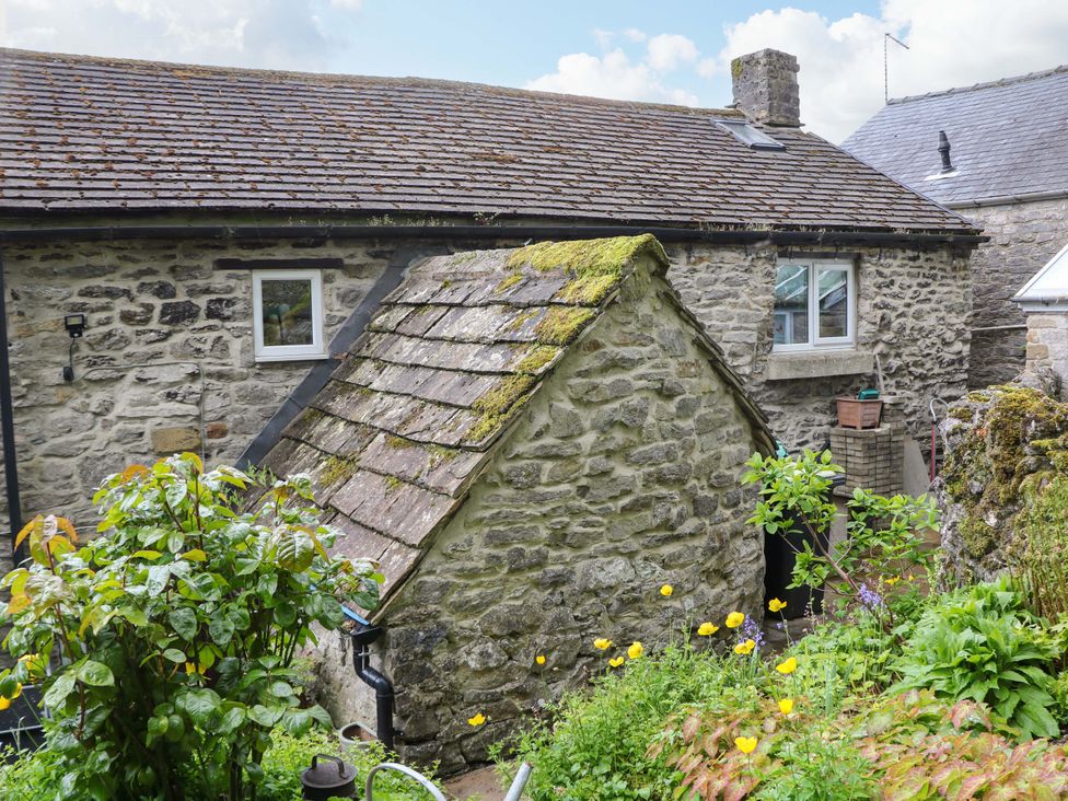 A stone building with a roof and a window at Bargate Cottage in Hope Valley